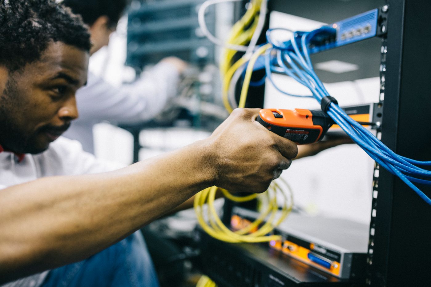 Technicien ORDINAT installant un cable reseau sur un serveur en armoire
